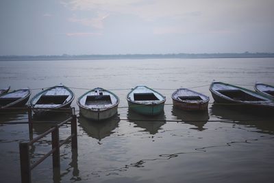 Boats moored in sea against sky