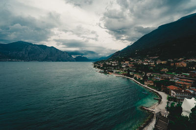 Aerial view of buildings by sea against sky