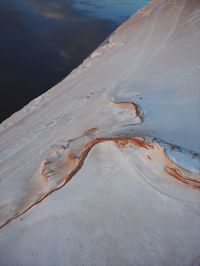 Aerial view of sand dunes at beach against sky