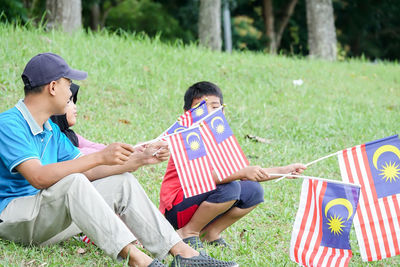 Smiling family holding malaysian flag