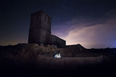 Low angle view of old building against sky at night