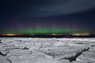 Scenic view of snow covered landscape against sky at night