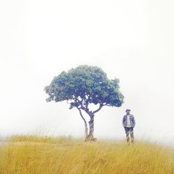 Man standing on field against sky