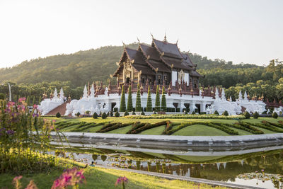 Built structure by lake against sky