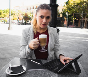Young woman drinking coffee in city