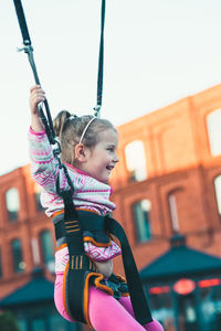 Girl bungee jumping against clear sky