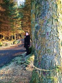 Woman standing on tree trunk