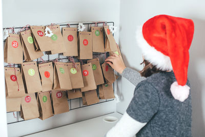 Rear view of woman standing by christmas lights