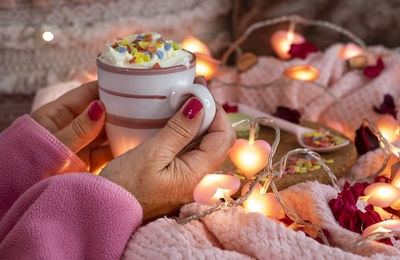 Close-up of hand holding lit candles