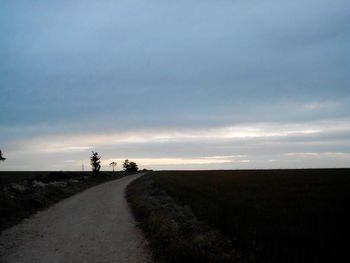 Country road against cloudy sky