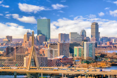 Modern buildings in city against cloudy sky