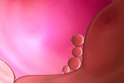 Full frame shot of water drops on pink background