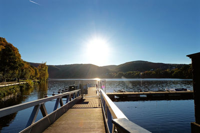 Pier over lake against clear sky