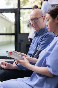 Side view of man using mobile phone while sitting at home