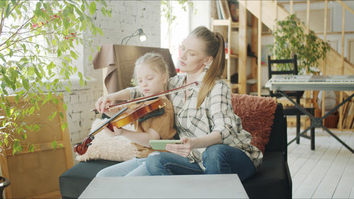 Teacher teaching violin to student at home