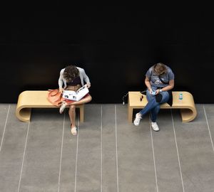 Full length of friends sitting on seat