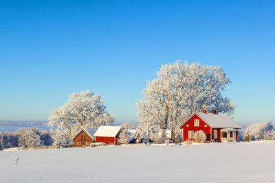 Farm by a snowy field on a beautiful winter day