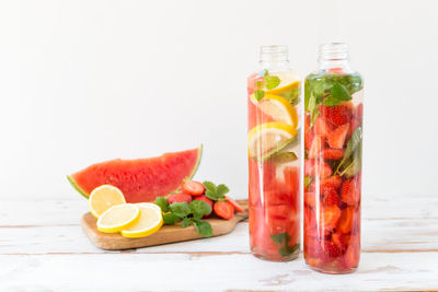 Various fruits on table against white background