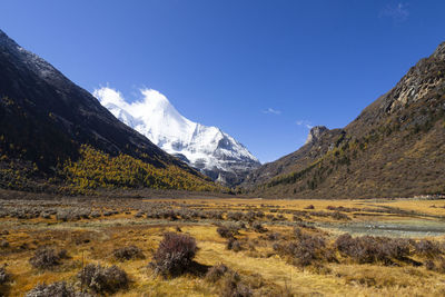 Scenic view of mountains against blue sky