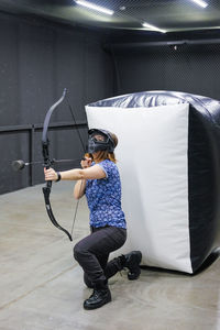 Full length side view of woman holding camera