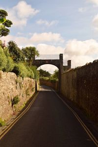 Road by bridge against sky