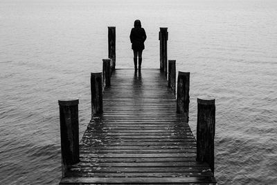 Silhouette woman standing on pier against lake