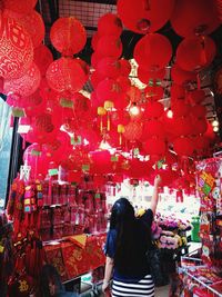 Rear view of woman standing against red lanterns