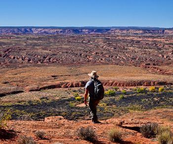 Rear view of man on mountain against sky