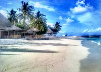 Scenic view of beach against cloudy sky