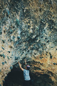 Side view of mid adult woman standing at cave