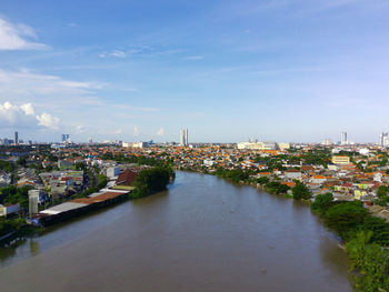 High angle view of river amidst buildings in city against sky