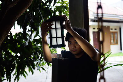 Portrait of young man repairing a garden lamp