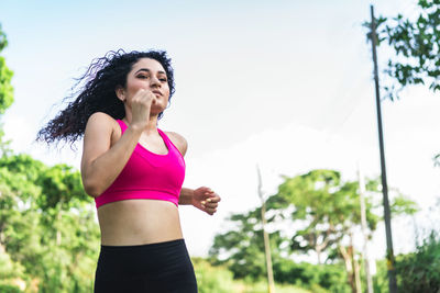 Beautiful young curly hair girl woman running outside, making exercise