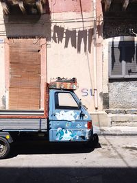 Vintage car on street against buildings in city