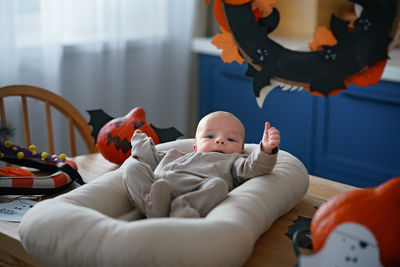 A small child lies surrounded by halloween decorations
