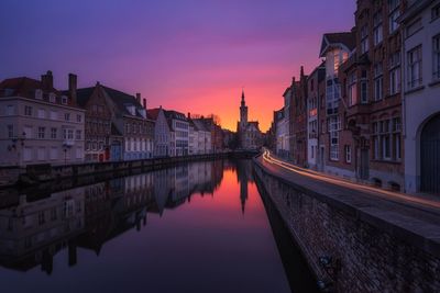 Reflection of buildings in city at sunset