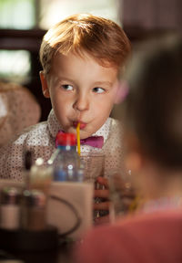 Close-up of cute boy drinking at restaurant
