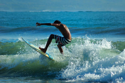 Full length of man splashing water in sea
