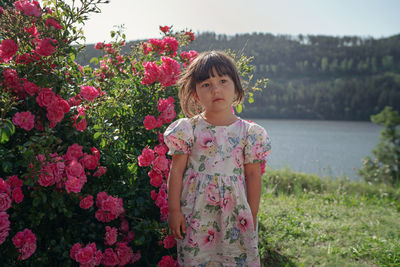 Portrait of cute girl standing on pink flower field