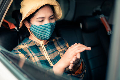 Portrait of man holding camera in car