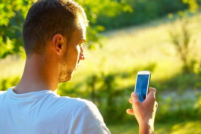 Young man using mobile phone outdoors