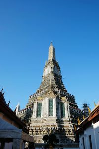 Low angle view of wat arun against clear blue sky on sunny day