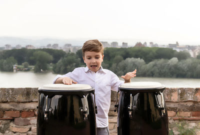 Portrait of boy in lake against sky