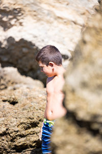 Little kid on a rocky beach in spain