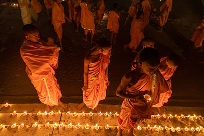 Group of people against illuminated fire at night