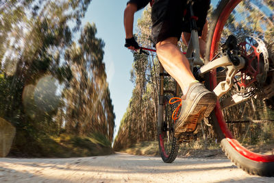 Low section of man riding bicycle on road