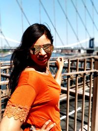 Portrait of young woman wearing sunglasses standing outdoors