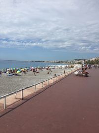 People on beach by sea against sky
