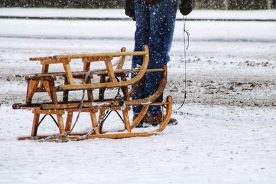 Low section of person standing on snow covered land