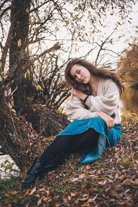 Young woman smiling while sitting on land